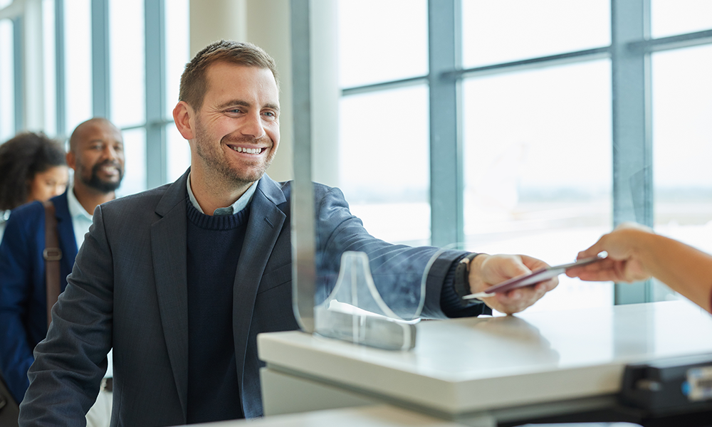 Best Travel Insurance: How to Choose the Right Plan in 2026 – traveler comparing travel insurance plans on a laptop with passport, suitcase, boarding pass, and world map before an international trip.